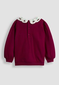 Suéter burdeos de manga larga, con un cuello de encaje blanco con detalles rojos. La parte posterior tiene un cierre de tres botones debajo del cuello.