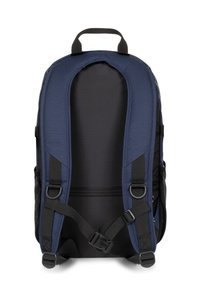 Mochila azul marino con detalles en negro, respaldo acolchado, correas ajustables y asa superior. Cuenta con bolsillos laterales y herrajes resistentes.