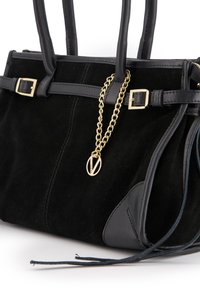 Sac à main en suede noir avec des accents en cuir, présentant des garnitures dorées, un ornement en chaîne et une sangle réglable. Surface texturée et forme structurée.