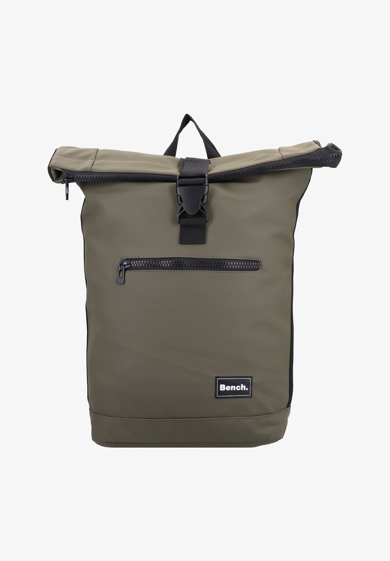 Sac à dos à rabat olive en matériau imperméable, avec une poche zippée à l'avant et des accessoires noirs avec un patch logo.