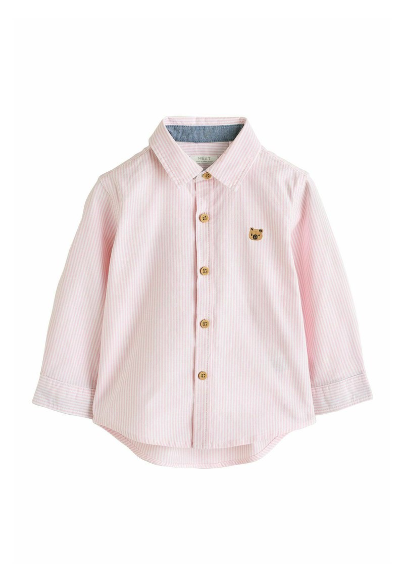 Jasnoróżowa i biała w paski koszulka z długim rękawem dla małych dzieci z drewnianymi guzikami i haftem małej brązowej twarzy niedźwiadka na piersi.