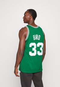 Grünes Basketballtrikot aus Meshstoff, mit weißem "BIRD"-Text und der Nummer "33" auf dem Rücken, und einem kontrastierenden gerippten Kragen.
