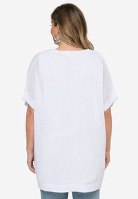 Top de punto blanco de gran tamaño con mangas cortas, con un ajuste holgado y textura de malla abierta. Acentuado con un dobladillo acanalado en la parte inferior.
