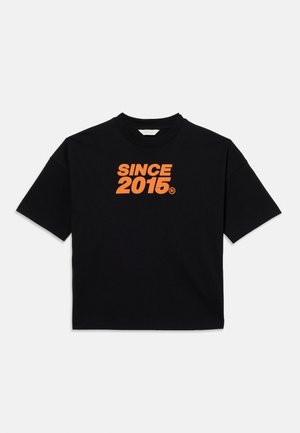 Zwart t-shirt met korte mouwen en oranje tekst "SINCE 2015" gedrukt op de borst, tentoongesteld tegen een effen lichte achtergrond.