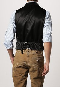 Schwarzer Satin-Weste mit taillierter Passform, verstellbarem Schnallenverschluss auf der Rückseite, getragen über einem gemusterten blau-weißen Karoshemd, kombiniert mit hellbraunen Hosen.