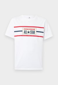 Λευκό βαμβακερό t-shirt με οριζόντιες ρίγες σε κόκκινο και ναυτικό μπλε, με κεντρικό λογότυπο "Converse All Star" σε μπεζ φόντο.