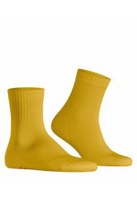 Gelbe Baumwollsocken mit gerippten Bündchen und glatter Textur. Mit einem dezenten Logo in Rot auf den Sohlen. Knöchellanges Design.