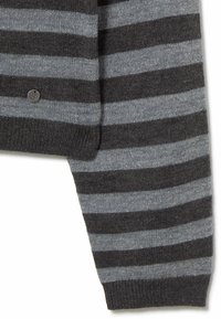 Suéter a rayas grises y negras con una textura suave. Presenta un brillo sutil y una pequeña etiqueta circular con el logo cerca del dobladillo.