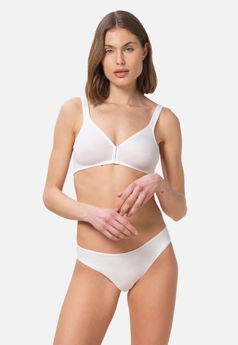 Bílý bavlněný bralet s širokými ramínky a měkkými košíčky, s véčkovým výstřihem a předním zapínáním na tři knoflíky; doplněný o odpovídající bílé kalhotky.