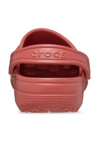 Korallenfarbene Crocs mit einem Rückenriemen, hergestellt aus strapazierfähigem, strukturiertem Schaumstoff, mit einem gemusterten Fußbett und einer gepunkten Sohle für bessere Haftung.