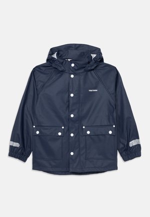 Chaqueta de lluvia azul marino con capucha, botones de presión delanteros, dos bolsillos con solapa, puños elásticos con tiras reflectantes y logo de Tretorn en el pecho.