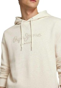 Sudadera beige con cordón, que presenta un logo en relieve de "Pepe Jeans London" en el pecho y puños acanalados. Tejido suave y texturizado.