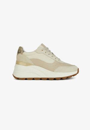 Zapatillas deportivas beige con una suela gruesa blanca y marrón. Presentan materiales de suave ante y piel lisa, acentos dorados y un respaldo texturizado.