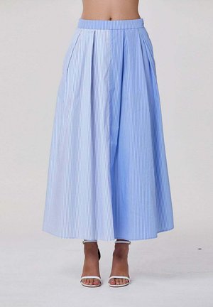 Jupe midi taille haute à jambes larges avec rayures verticales bleues et blanches portée avec des talons blancs ouverts à la pointe et à bride cheville.