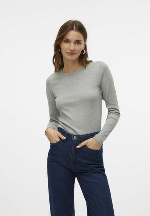 Grijs longsleeve shirt van zacht materiaal, met een ronde hals. Gecombineerd met donkerblauwe high-waisted jeans. Minimalistisch ontwerp.