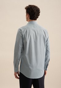 Camicia a maniche lunghe da uomo in pattern a quadri blu chiaro e bianco, con colletto a punta e polsini con bottone, realizzata in un morbido tessuto misto cotone.