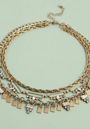Guld flerlagershalsband med kedjor av varierande mönster, prytt med rektangulära metallplattor och funklande rhinestones.