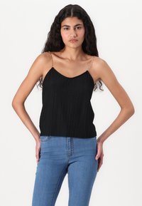 Svart, plisserad tanktop med tunna kedjestraps. Tyget har en strukturerad yta och en lös passform med rundad halsringning.