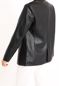 Schwarze Lederblazer mit klassischem Schnitt, ausgestattet mit einer glatten Textur, langen Ärmeln und zwei Seitentaschen. Dezentes Rückenschlitzdetail.