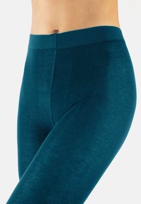 Turkusowe legginsy wykonane z teksturowanej dzianiny, z szerokim, elastycznym pasem w talii. Posiadają gładkie wykończenie i komfortowe dopasowanie w okolicy pasa.