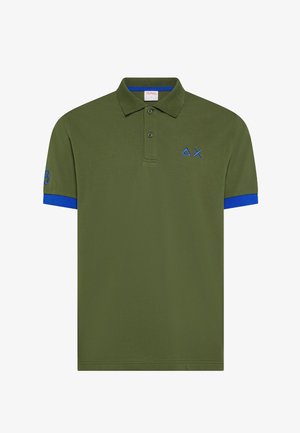 Polo verde oliva con rifiniture blu sulle maniche, due bottoni e un triangolo e una X ricamati in blu sul petto.