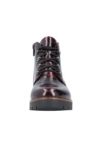 Bottes chelsea bordeaux en cuir verni avec des lacets noirs, finition texturée et semelle épaisse noire. Équipées d'une fermeture éclair sur le côté pour un enfilage facile.