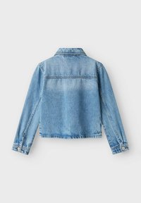 Ljusblå denimjacka med en kortad passform, knäppning med knappar, klassisk krage och långa ärmar. Har en blekt textur och fransad nederkant.