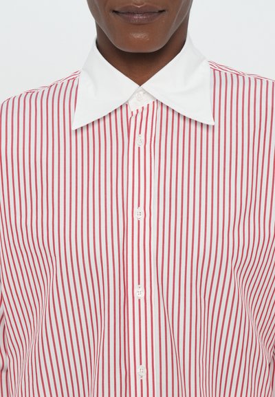 Red and white striped button-up shirt with a white collar and front placket featuring white buttons. Stripes are vertically aligned.