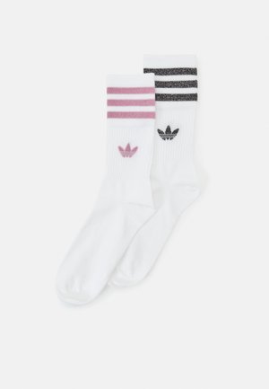 Two pairs of white athletic socks, one with pink stripes and logo, the other with black stripes and logo, ribbed texture, mid-calf length.