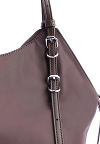 Bolso de mano de cuero marrón con una textura suave, equipado con herrajes plateados y una correa ajustable con múltiples anillas para la regulación de la longitud.