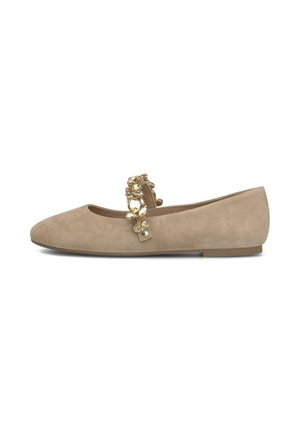 Zapato plano de ante beige con punta redondeada y una correa decorativa adornada con grandes piedras preciosas doradas y transparentes.