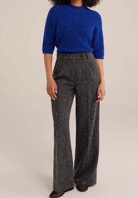 Maglione corto a maniche corte di un blu reale con una texture morbida, abbinato a pantaloni grigi a gamba larga a vita alta con un motivo sottile e un dettaglio a bottoni.