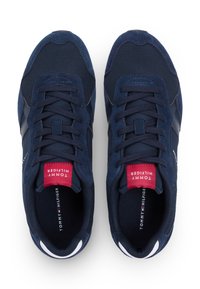 Αθλητικά παπούτσια σε ναυτικό μπλε χρώμα με υφές σουέντ και δίχτυ, με κόκκινες και λευκές λεπτομέρειες, στρογγυλή μύτη και επίπεδα κορδόνια. Λογότυπο στη γλώσσα.