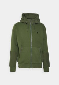 Grön huvtröja med dragkedja, med två fickor med dragkedja, ribbade ärmar och en liten logotyp på bröstet.