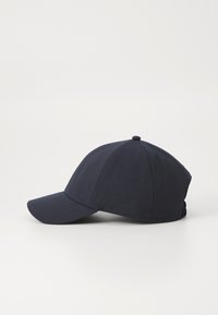 Námořnická modrá baseballová čepice vyrobená z texturované látky, s křivým šiltem a vyšitým logem na boku. Hladký povrch, klasický design.