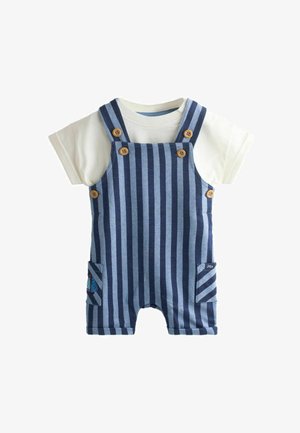 Salopette corta a righe blu e blu navy con bottoni in legno indossata sopra una maglietta bianca a maniche corte per neonati.