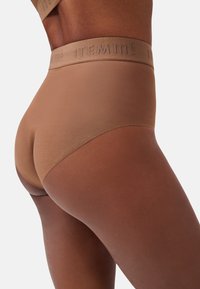 Mutande hipster marroni con un design morbido e senza cuciture e una fascia elastica grande con il nome del marchio impresso. Texture liscia e opaca.