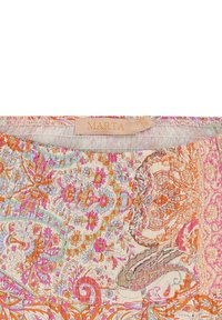 Mønstrede stoffer med indviklede blomstermønstre i orange, pink og blå. Har en samlede, elastisk halsudskæring og et mærke med teksten "MARTA."