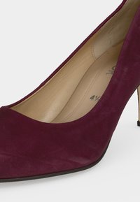 Chaussure à talon haut en daim bordeaux foncé avec bout pointu et intérieur en cuir beige, taille 4½ visible à l'intérieur.