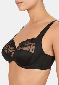 Czarny biustonosz z przezroczystą koronką na górze, ozdobioną haftem kwiatowym, z fiszbinami oraz szerokimi regulowanymi ramiączkami dla wsparcia.