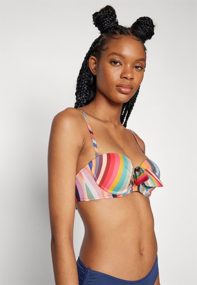 Krāsu raibi svītrainais bikini tops ar polsterētiem kausiem, lentes detaļas centrā un regulējamām siksnām. Materiāls izskatās gluds ar spilgtu rakstu.