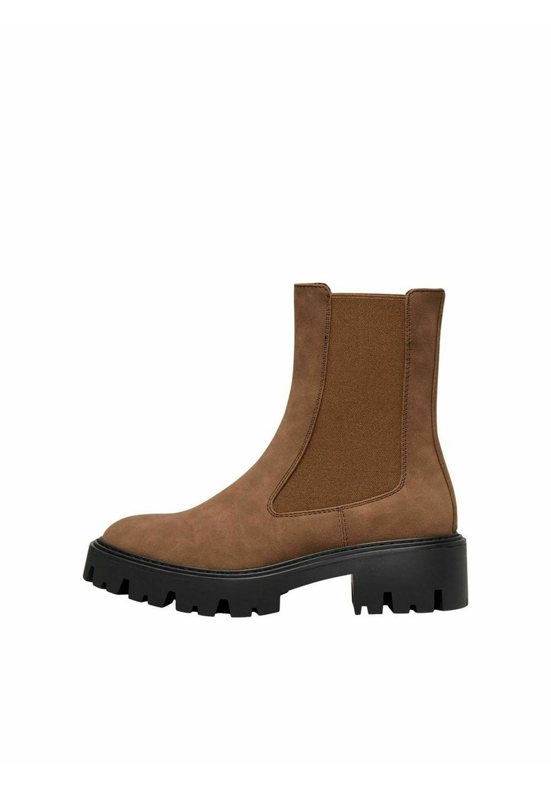 Bottine en suede marron avec des panneaux latéraux élastiques, une surface texturée, une semelle extérieure noire chunky et un bout arrondi. Design simple et fonctionnel.