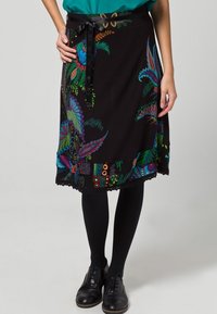 Czarna spódnica z żywymi kwiatowymi i abstrakcyjnymi wzorami w odcieniach niebieskiego, zielonego i czerwonego, z wiązaniem w talii i koronkowym wykończeniem na brzegu.