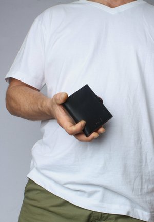 Black leather wallet held in a hand, featuring a rectangular shape with a smooth texture and subtle embossed logo on one side.