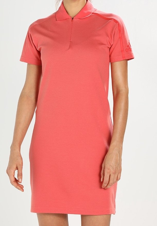 Sukienka polo w koralowym różu, krótkie rękawy, wykonana z gładkiego materiału. Posiada kołnierzyk oraz zamek błyskawiczny o długości ćwierć rękawa. Niewielkie logo na rękawie.