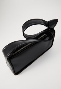 Črna usnjena torbica pravokotne oblike, z zadrgo in enim zaobljenim ročajem. Gladka tekstura in minimalističen dizajn.