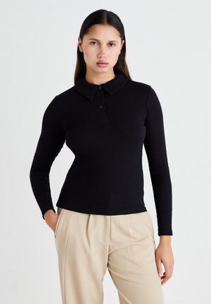 Svart langermet polo skjorte med krage, med en knappestolpe foran. Myk, ribbet tekstur og tettsittende design.