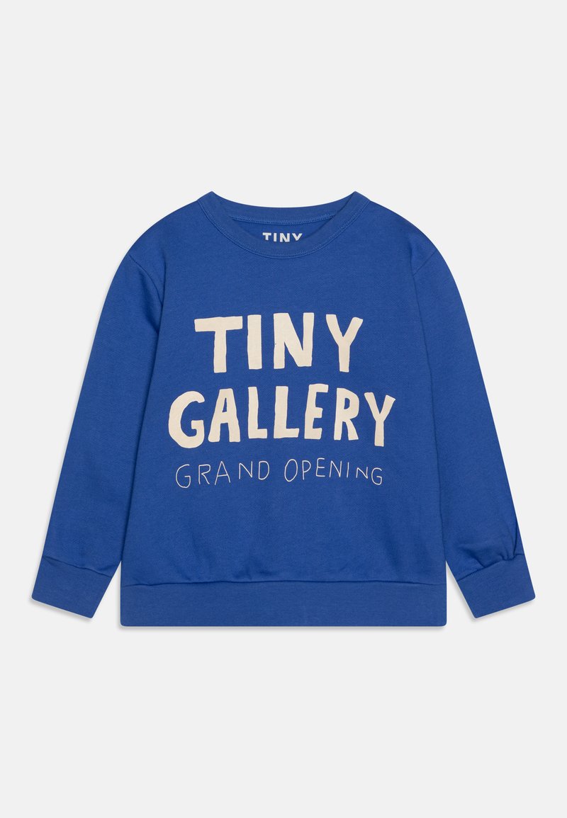 Niebieska bluza z bawełny, z okrągłym dekoltem i długimi rękawami. Na przodzie znajduje się nadrukowany tekst "TINY GALLERY GRAND OPENING" w kolorze beżowym.