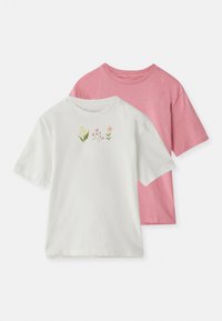 Deux T-shirts à manches courtes empilés : l'un blanc avec une broderie florale colorée sur la poitrine, et l'autre rose uni. Les deux en coton doux.