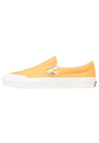 Gelbe Slip-On-Schuhe aus Canvas mit weißer Gummisohle; verfügen über elastische Seiteneinsätze und ein kleines Logotag an der Außenseite.